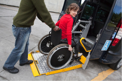 woman in a wheelchair getting loaded into a van